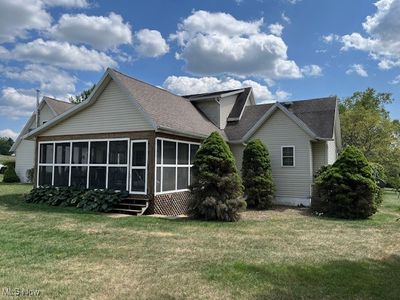 Back of house with a lawn and a sunroom | Image 3