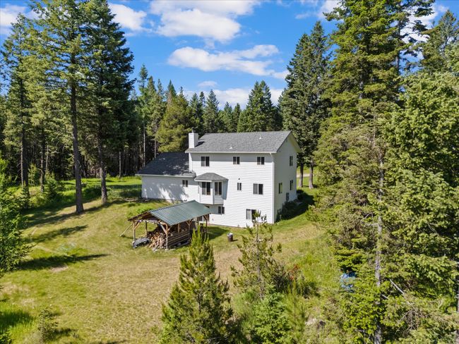 Aerial view of property and surrounding area with a heavily wooded area | Image 44