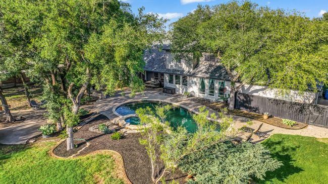 Back of property with a fenced backyard, a patio area, a pool with connected hot tub, and roof with shingles | Image 33