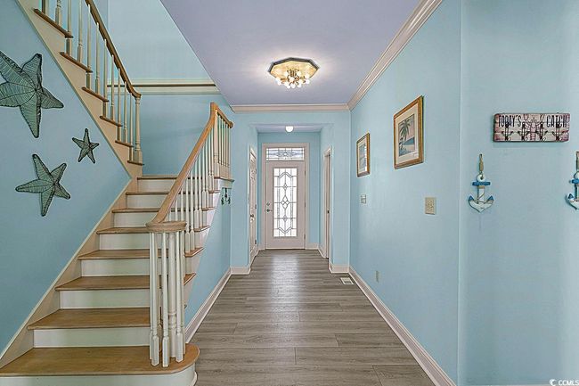 Foyer entrance featuring stairs, ornamental molding, wood finished floors, and baseboards | Image 7