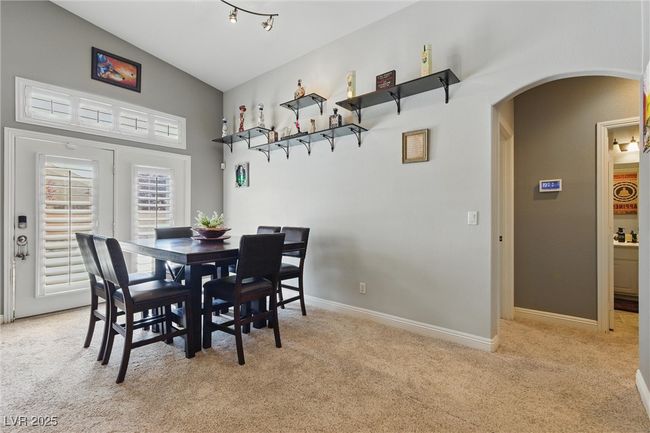 Dining space with light carpet, baseboards, arched walkways, and high vaulted ceiling | Image 11