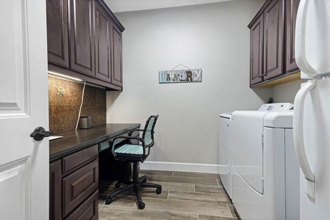 Laundry area featuring cabinet space, washing machine and dryer, baseboards, light wood-style floors, and an office area | Image 23
