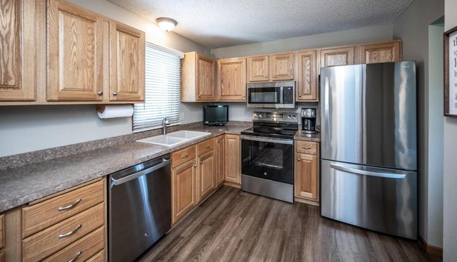Kitchen features *(exhaust vented to outside), abundant oak raised-raised panel cabinets, double pantry, window above sink with views to deck & backyard, newer SS appliances include refrigerator, range, built-in microwave, dishwasher & disposal. | Image 9