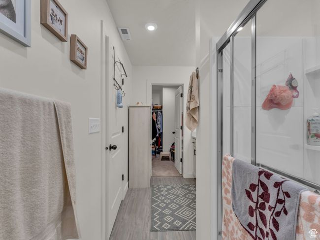 Full bathroom with wood finished floors, a shower stall, a walk in closet, and recessed lighting | Image 20