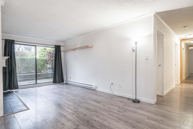 Unfurnished room featuring baseboard heating, a textured ceiling, crown molding, and wood finished floors | Image 8
