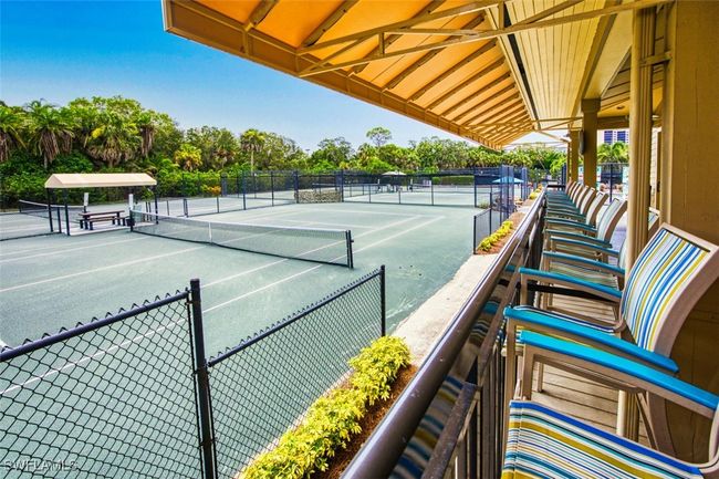 View of tennis court with view of scattered trees | Image 49