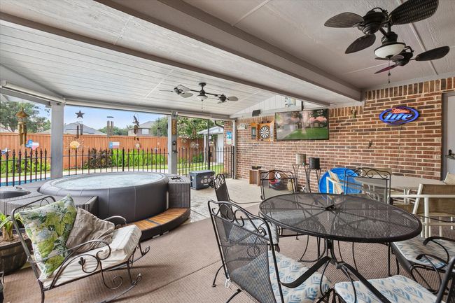 View of patio with ceiling fan, outdoor dining space, and a hot tub | Image 24