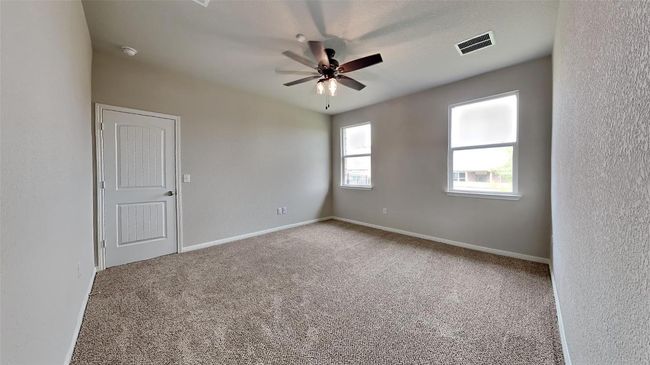 Carpeted spare room featuring a ceiling fan, baseboards, and a smoke detector | Image 5