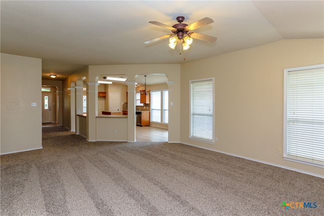 Living room showing bar area off the kitchen and front hallway. | Image 19