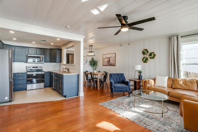 Living room featuring ceiling fan, ornamental molding, and light wood-style floors | Image 7