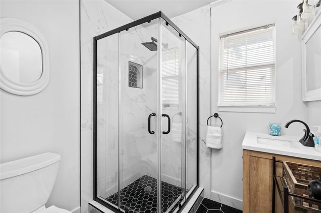 Bathroom with a marble finish shower, vanity, and toilet | Image 16