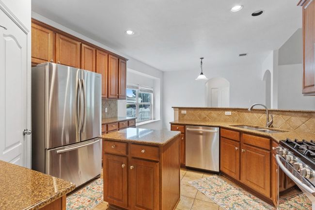 Kitchen featuring stainless steel appliances, a sink, arched walkways and recessed lighting | Image 7