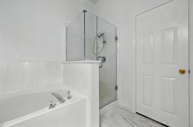 Full bath with a shower stall, a bath, and marble look tiles | Image 25