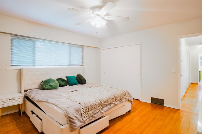 Bedroom featuring light wood-type flooring, baseboards, visible vents, a ceiling fan, and a closet | Image 19