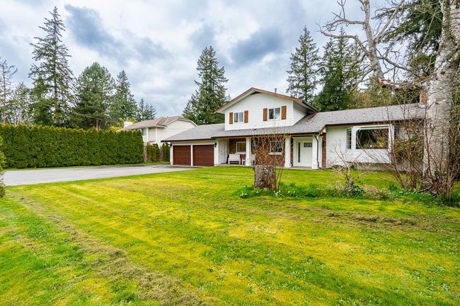 View of front of house featuring a front lawn, driveway, a porch, and an attached garage | Image 37