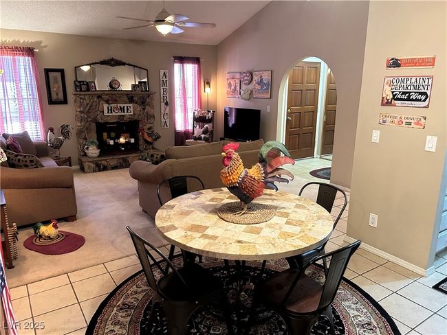 Dining area with a ceiling fan, arched walkways, plenty of natural light, light tile patterned flooring, and vaulted ceiling | Image 11