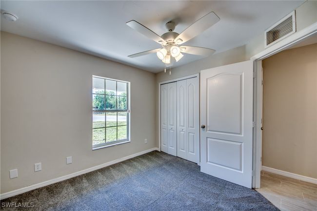 Unfurnished bedroom featuring a ceiling fan, visible vents, baseboards, a closet, and carpet | Image 36