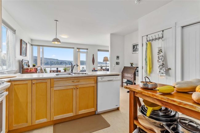 Kitchen featuring a sink, light brown cabinets, light countertops, dishwasher, and pendant lighting | Image 13