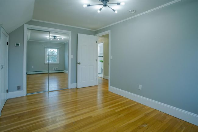 Unfurnished bedroom featuring light hardwood / wood-style floors, baseboard heating, and a closet | Image 14