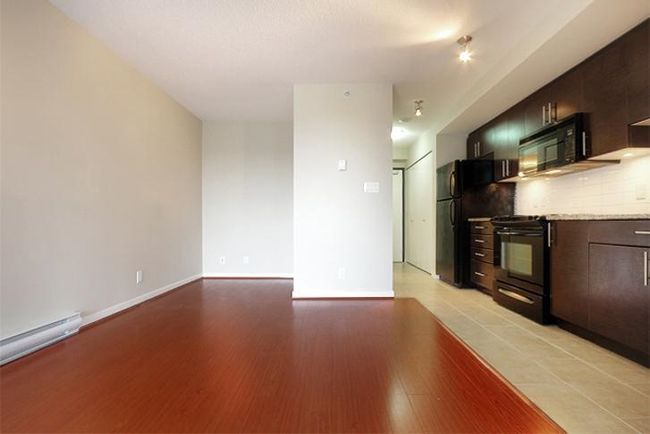 Kitchen with backsplash, light countertops, light wood-type flooring, black appliances, and baseboard heating | Image 10