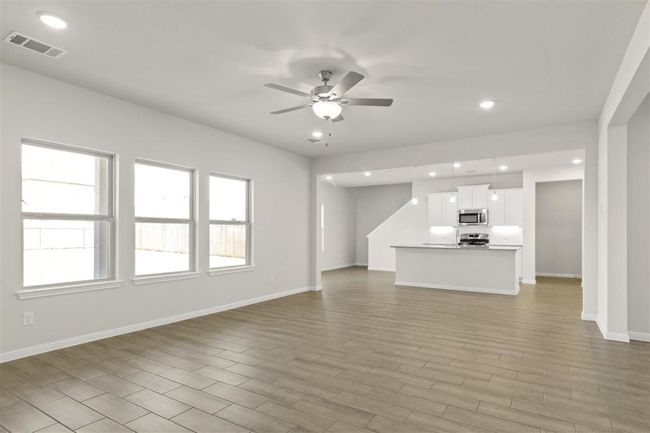 Unfurnished living room with ceiling fan, visible vents, recessed lighting, light wood finished floors, and baseboards | Image 6