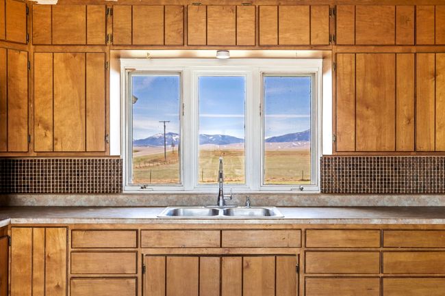 Kitchen featuring a mountain view, tasteful backsplash, light countertops, and a sink | Image 22