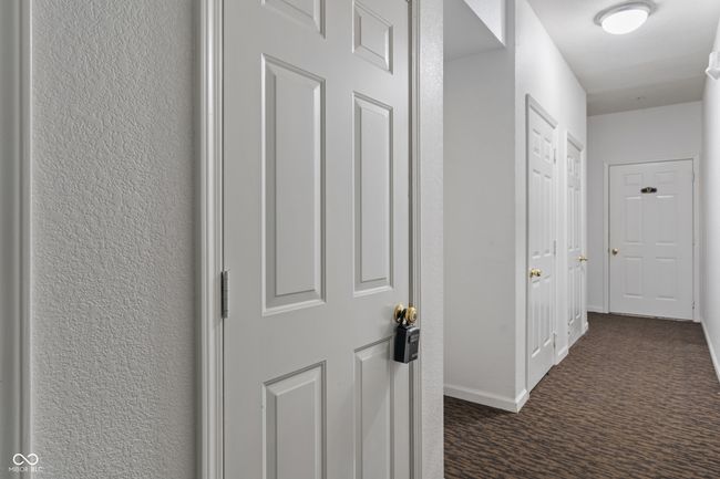 Included is a storage closet located directly across the hall from the condo door, with the condo's designated garage access door in the background, garage #57 | Image 10