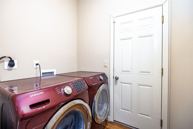 Laundry room featuring washing machine and clothes dryer, wood finished floors, and laundry area | Image 21