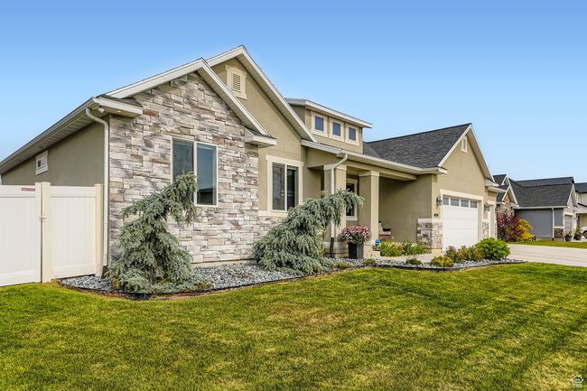 Craftsman-style house with stone siding, stucco siding, driveway, and an attached garage | Image 25