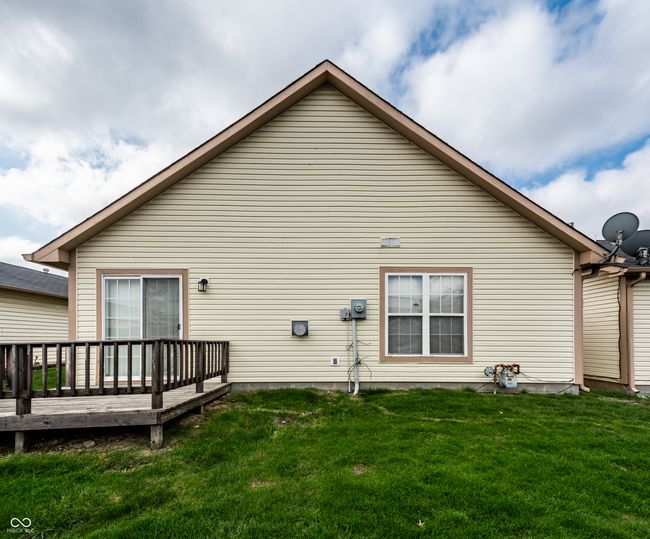 rear view of house with well maintained lawn and a deck | Image 23