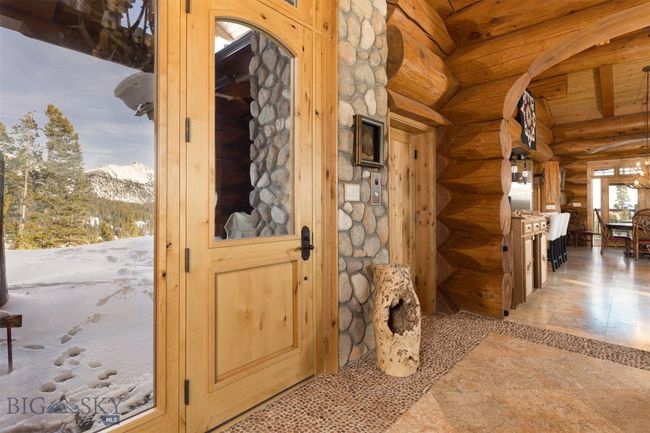 Main level entryway door, elevator door and carved archway to great room. | Image 25