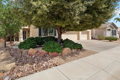 The front side entry is shady and inviting with nice color plants and trees. | Image 2