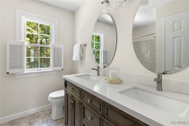 Second floor hall Bathroom featuring double vanity, tiled floor, toilet, tiled tub/shower and linen closet | Image 30