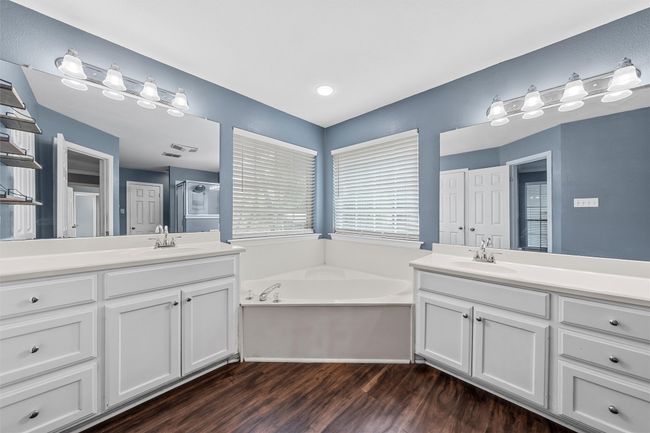 Bathroom featuring two vanities, a garden tub, wood finished floors, and a shower stall | Image 15