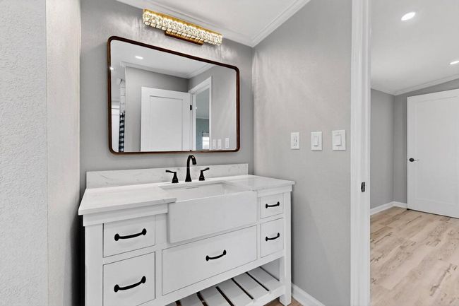 Bathroom with crown molding, wood finished floors, vanity, baseboards, and recessed lighting | Image 27