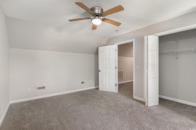 Unfurnished bedroom featuring a closet, vaulted ceiling, carpet flooring, baseboards, and visible vents | Image 20