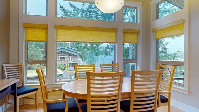 Dining space featuring baseboards, a high ceiling, and wood finished floors | Image 11