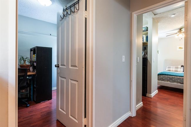 Hallway with a textured ceiling and dark wood-style floors | Image 14