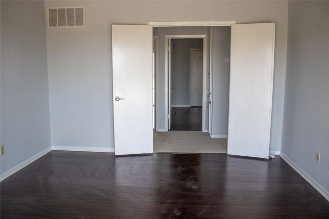Spare room featuring baseboards, wood finished floors, and visible vents | Image 19