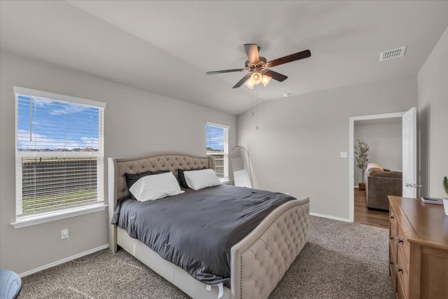 Bedroom featuring light colored carpet, baseboards, and a ceiling fan | Image 11