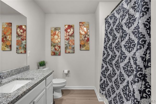 Full bathroom with toilet, vanity, baseboards, and wood finished floors | Image 21