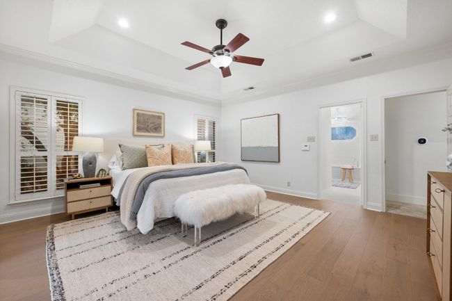 Bedroom with a raised ceiling, wood finished floors, recessed lighting, ceiling fan, and ornamental molding | Image 16