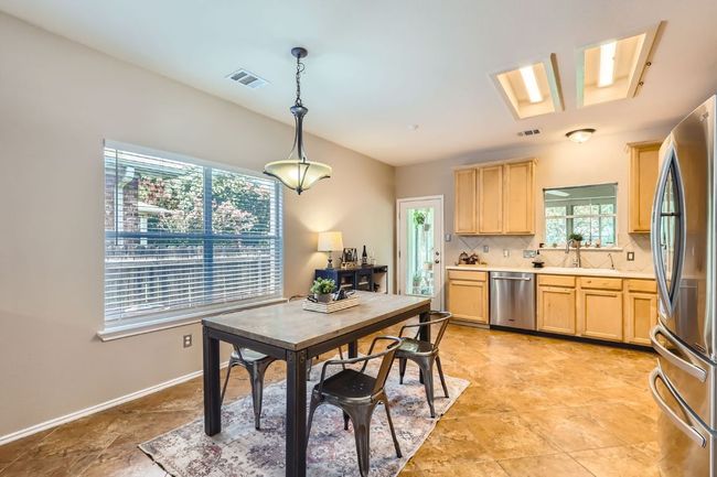 Kitchen featuring stainless steel appliances, light brown cabinets, healthy amount of natural light, and light countertops | Image 9