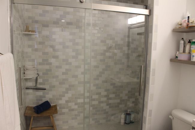 Full bathroom featuring a stall shower and toilet | Image 11