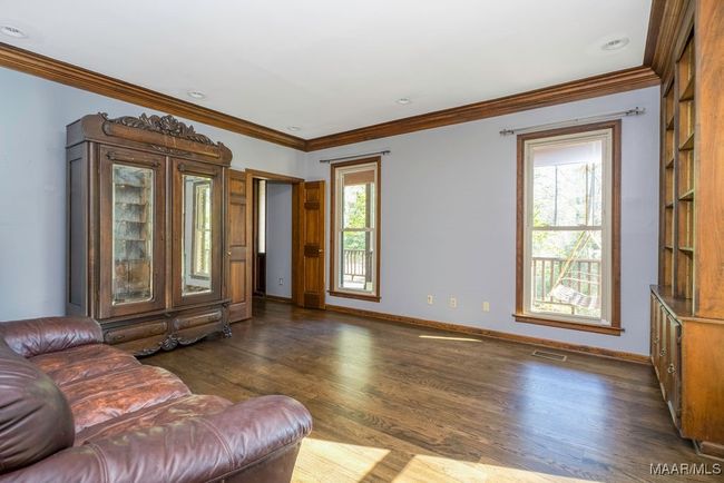 From the front foyer to the left is a formal living room or library or study. Again beautiful hardwood! | Image 17