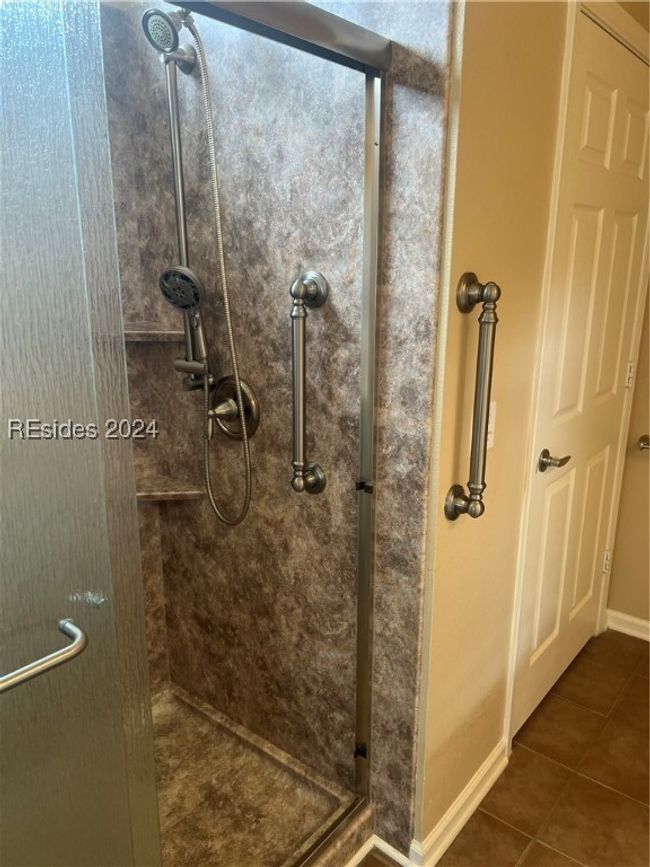 Bathroom with a shower with door and tile patterned floors | Image 21