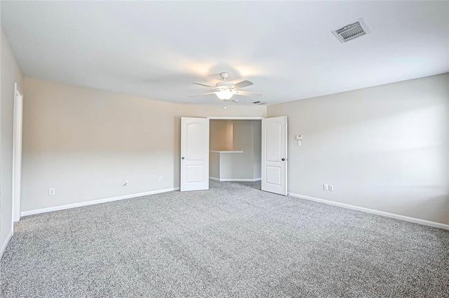 The primary suite includes double doors, large walk in closet and well appointed bathroom. | Image 25