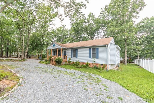 Ranch-style house with covered porch, driveway, crawl space, a shingled roof, and view of scattered trees | Image 41