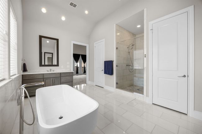 Full bath with a shower stall, a soaking tub, vanity, lofted ceiling, and recessed lighting | Image 22