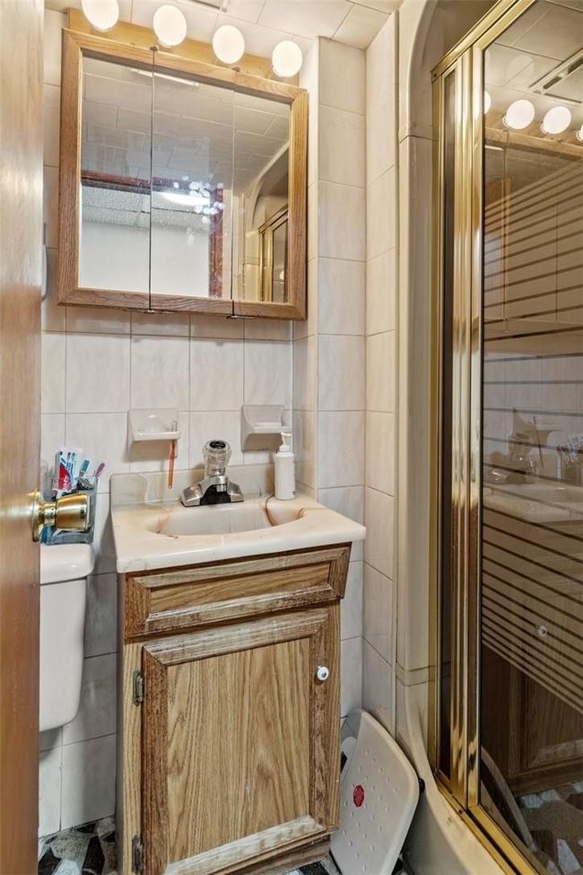 Bathroom with tasteful backsplash, vanity, tile walls, and toilet | Image 23